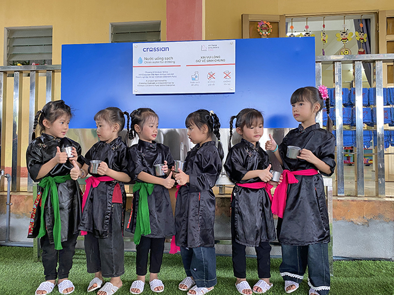 Các học sinh hân hoan sử dụng nước sạch từ hệ thống Các học sinh hân hoan sử dụng nước sạch từ hệ thống